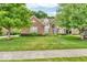 Charming two-story brick home with well-manicured lawn, mature trees, and inviting curb appeal at 5865 Osage Dr, Carmel, IN 46033