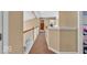 Neutral toned hallway with wood railing and white trim showcasing the home's transitional design at 5865 Osage Dr, Carmel, IN 46033