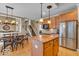 Bright kitchen space blending into dining area and stairs, island, stainless steel refrigerator, and wooden cabinets at 5865 Osage Dr, Carmel, IN 46033