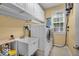 Practical laundry room area with cabinetry, utility sink and a modern washing machine at 5865 Osage Dr, Carmel, IN 46033