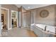 Elegant main bathroom with tile floors, a whirlpool tub, walk-in shower, and access to a walk-in closet at 5865 Osage Dr, Carmel, IN 46033