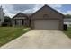 Charming brick home featuring an attached two car garage and a well-manicured front lawn at 5954 Honeywell Dr, Indianapolis, IN 46236