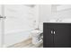 Bathroom featuring a tub-shower, toilet, and vanity with sleek black cabinetry, offering comfort and style at 602 W 34Th St, Anderson, IN 46013