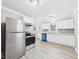 Bright kitchen featuring stainless steel appliances, white cabinetry, and wood-look vinyl flooring at 602 W 34Th St, Anderson, IN 46013