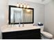 Bathroom with sleek black vanity, white countertop, mirror, and modern lighting at 6126 Navy Cir, Indianapolis, IN 46221