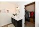 Bathroom features a stylish vanity with a round mirror and an adjacent walk-in closet at 6126 Navy Cir, Indianapolis, IN 46221