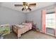 Bright bedroom with a ceiling fan, large window, and decorative pink curtains at 6126 Navy Cir, Indianapolis, IN 46221