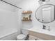 Neutral bathroom features a shower with white curtain, floating shelves, and updated vanity at 6142 Evanston Ave, Indianapolis, IN 46220