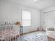 Neutral Bedroom features a crib with floral bedding, patterned rug, and a sitting chair at 6142 Evanston Ave, Indianapolis, IN 46220