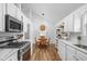 Eat-in kitchen boasts light-filled dining area with a wooden table and view of the kitchen at 6142 Evanston Ave, Indianapolis, IN 46220