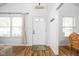 Inviting entryway with hardwood floors, a white front door with glass panes, and neutral walls at 6142 Evanston Ave, Indianapolis, IN 46220