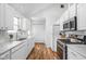 Bright kitchen with white cabinets, stainless steel appliances, and wood flooring at 6142 Evanston Ave, Indianapolis, IN 46220