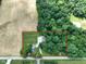 Aerial view of the property, showcasing the house, outbuilding, and surrounding greenery and fields at 6208 S 200 W, Trafalgar, IN 46181