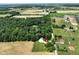 Aerial view of home with outbuildings, large fields, and tree lined property at 6208 S 200 W, Trafalgar, IN 46181