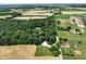 Picturesque aerial view of property with home, outbuildings, fields and lush green trees at 6208 S 200 W, Trafalgar, IN 46181