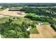 Aerial view of property surrounded by sprawling fields, trees, outbuildings, and lush vegetation at 6208 S 200 W, Trafalgar, IN 46181