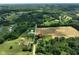 Expansive aerial view of lush acreage, mature trees, and a charming home with outbuildings at 6208 S 200 W, Trafalgar, IN 46181