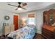 Cozy bedroom featuring hardwood floors, a ceiling fan, and large armoire at 6208 S 200 W, Trafalgar, IN 46181