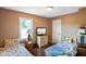 Bedroom with hardwood floors featuring two twin beds, a window, and closet door at 6208 S 200 W, Trafalgar, IN 46181