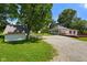 Quaint home featuring a charming porch, driveway, and a lush green lawn and tall trees surrounding the property at 6208 S 200 W, Trafalgar, IN 46181