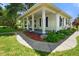 Inviting front porch featuring classic columns, manicured landscaping, and a cozy swing, perfect for relaxing at 6208 S 200 W, Trafalgar, IN 46181