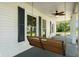 Relaxing front porch featuring a cozy swing, ceiling fan, and classic design elements, offering serene outdoor living at 6208 S 200 W, Trafalgar, IN 46181