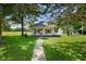 Charming home featuring a covered porch, beautiful landscaping, and mature trees on a well-maintained lawn at 6208 S 200 W, Trafalgar, IN 46181