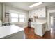 Bright kitchen features white cabinets, a stainless steel dishwasher, and hardwood floors at 6208 S 200 W, Trafalgar, IN 46181
