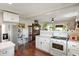 Open kitchen layout with white cabinets, stove and stainless steel refrigerator at 6208 S 200 W, Trafalgar, IN 46181