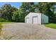 View of the barn-style outbuilding featuring two garage doors and gravel drive at 6208 S 200 W, Trafalgar, IN 46181