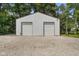 Barn-style outbuilding with two garage doors on a gravel drive on a sunny day at 6208 S 200 W, Trafalgar, IN 46181