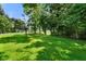 Expansive backyard with lush green grass and mature trees, offering privacy and a serene outdoor space at 6208 S 200 W, Trafalgar, IN 46181