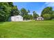 Spacious green yard with a large barn-style outbuilding and a single Gathering home on a sunny day at 6208 S 200 W, Trafalgar, IN 46181