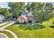 Beautiful aerial view of red brick home on landscaped lot with long driveway at 6374 Timberbluff Cir, Avon, IN 46123