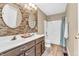 Well-lit bathroom features a double sink vanity with brown cabinets and a tile backsplash at 6374 Timberbluff Cir, Avon, IN 46123