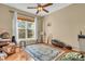 Sunlit bedroom with hardwood floors, a ceiling fan, and a large window with picturesque outdoor views at 6374 Timberbluff Cir, Avon, IN 46123