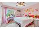 Cute bedroom with personalized decor, bright pink walls, and a large window overlooking the yard at 6374 Timberbluff Cir, Avon, IN 46123