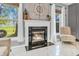Elegant fireplace with marble surround and decorative mantle, framed by sunlit windows and modern décor at 6374 Timberbluff Cir, Avon, IN 46123