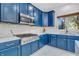 Bright kitchen boasts blue cabinets, stainless steel appliances, marble backsplash, and countertops at 6374 Timberbluff Cir, Avon, IN 46123