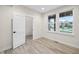 Bright bedroom features wood-look floors, neutral paint, and two windows with white trim allowing in natural light at 6553 Stone Pointe Way, Indianapolis, IN 46237