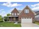 Beautiful two-story brick home with a covered front porch, an attached two-car garage, and well-manicured lawn at 6553 Stone Pointe Way, Indianapolis, IN 46237
