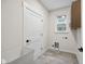 Bright laundry room features a utility sink, a window and a white door at 6553 Stone Pointe Way, Indianapolis, IN 46237