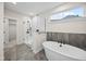 Luxurious main bathroom features a soaking tub, walk-in shower with glass enclosure, and neutral tile floors at 6553 Stone Pointe Way, Indianapolis, IN 46237