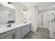 Bright main bathroom with gray cabinets, dual sinks, tile floors, and a walk-in shower with a glass enclosure at 6553 Stone Pointe Way, Indianapolis, IN 46237