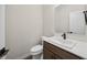 Well-lit powder room with a modern vanity featuring a white countertop, dark wood cabinets, and matte black faucet at 6553 Stone Pointe Way, Indianapolis, IN 46237