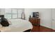 Bright bedroom featuring a large bed, dark wood floors, and plenty of natural light from the window at 6570 Freemont Ln, Carmel, IN 46033