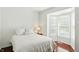 Cozy bedroom featuring a bay window, hardwood floors, and a comfortable bed with neutral-toned bedding at 6570 Freemont Ln, Carmel, IN 46033