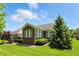 A brick home with a backyard deck and mature landscaping, with a lush green lawn at 6570 Freemont Ln, Carmel, IN 46033