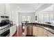 Modern kitchen with stainless steel appliances, white cabinets, and granite countertops open to the dining area at 6570 Freemont Ln, Carmel, IN 46033
