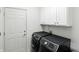 Functional laundry room with modern appliances, white cabinets for storage, and a utility door at 6570 Freemont Ln, Carmel, IN 46033